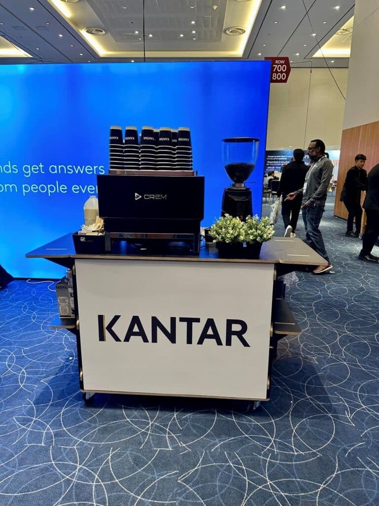 Kantar branded conference coffee bar by Tom’s Coffee with branded cups at a conference venue
