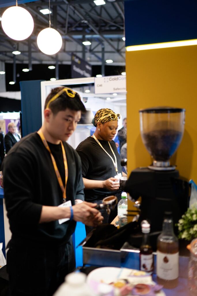 Tom&rsquo;s Coffee baristas Kai and Fai preparing espresso on an exhibition stand